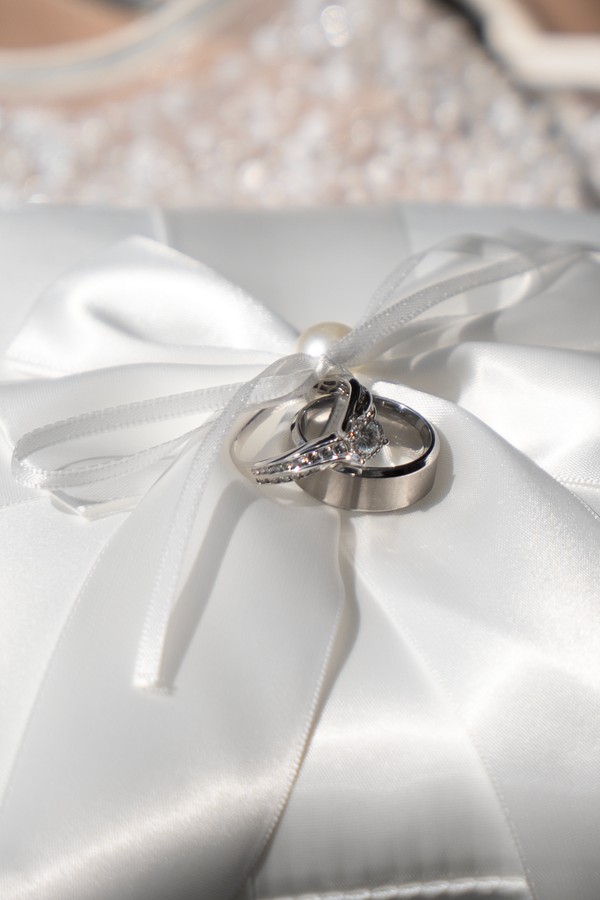 Wedding rings resting on an ivory satin bow