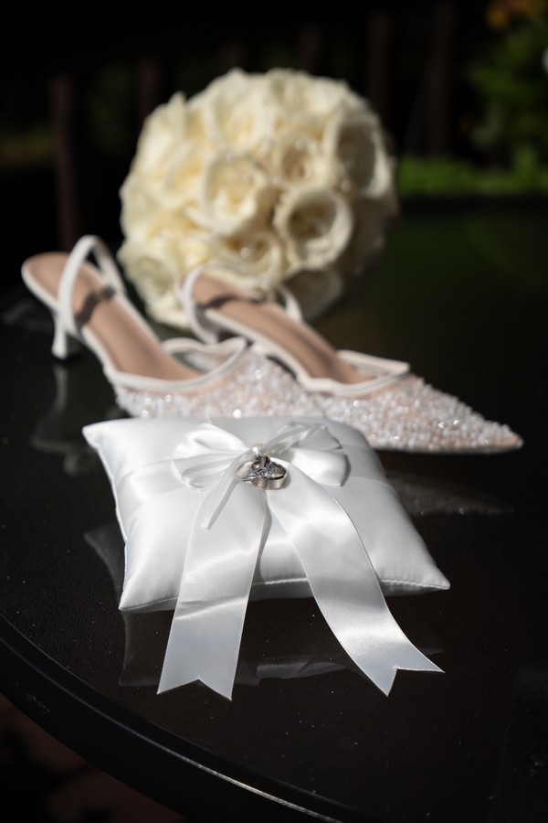 Bridal shoes, white roses and the wedding rings