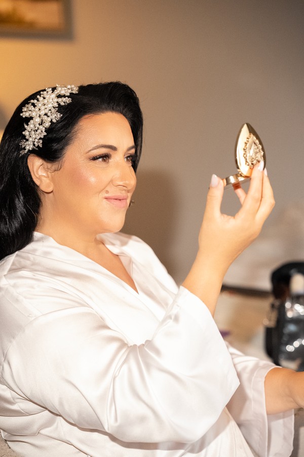 The bride making the final touches to her makeup