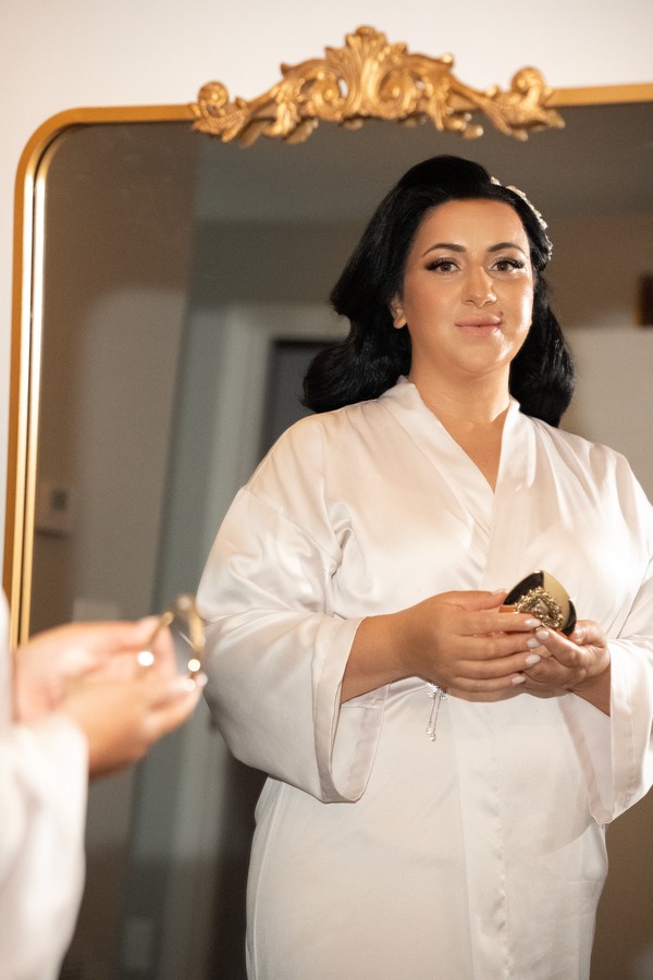 The bride reflected in a gold-framed mirror