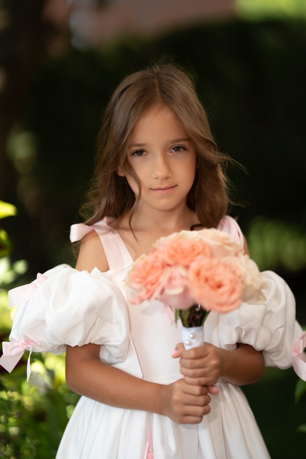 A flower girl holding her bouquet in the garden