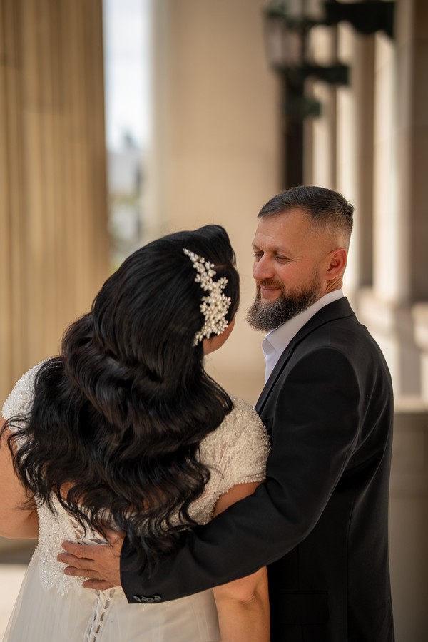 The couple embracing beside the columns