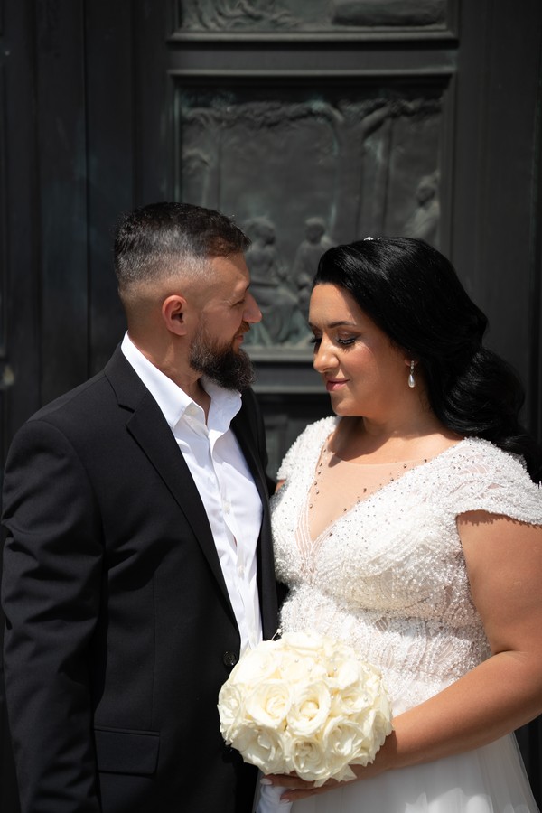 The couple looking at one another outside a carved doorway