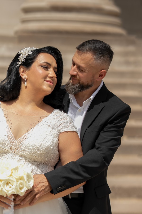 The bride and groom sharing a close embrace on the stone steps