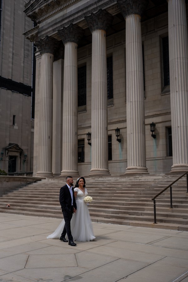 The newlyweds beneath the grand stone columns
