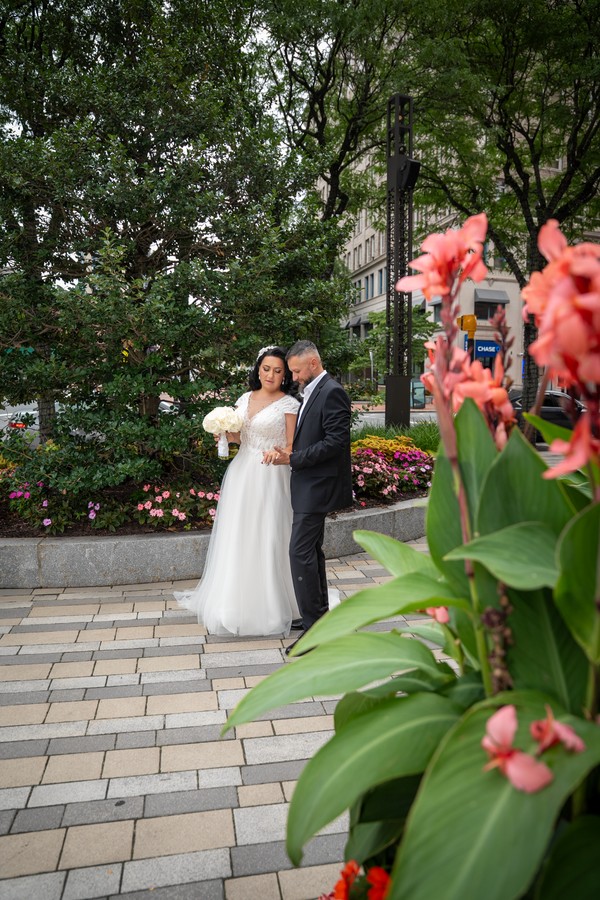 The couple framed by the garden’s summer flowers