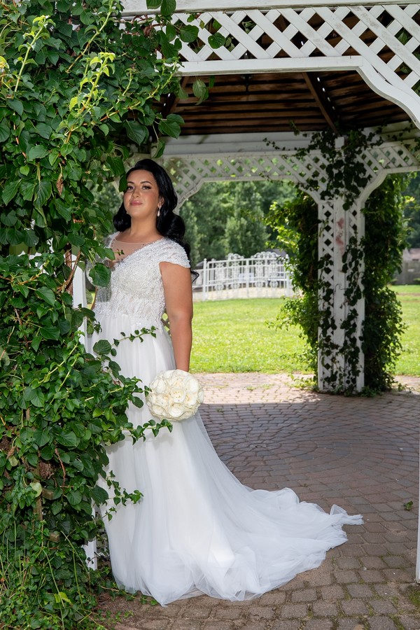 The bride framed by an ivy-covered garden arch