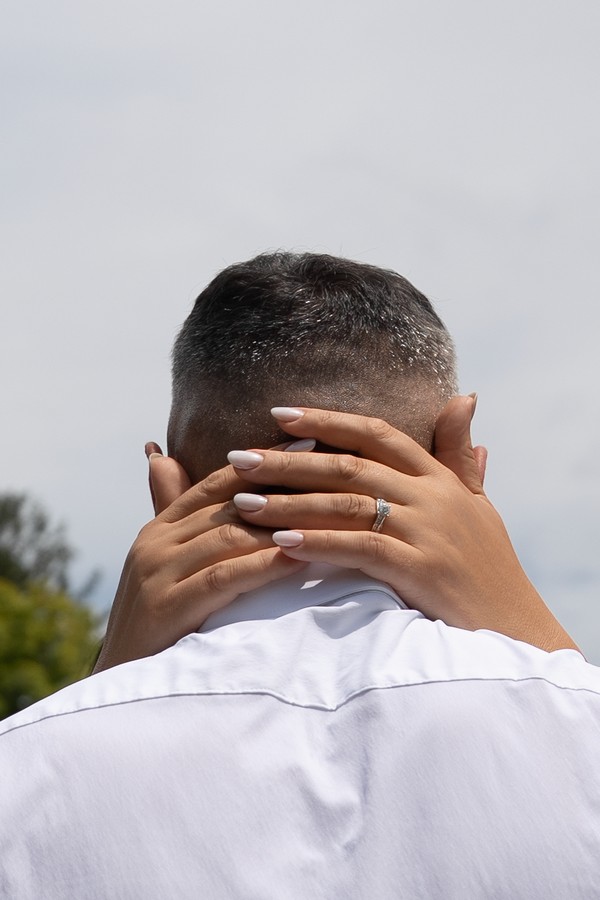 The bride’s hands resting on the groom’s shoulders