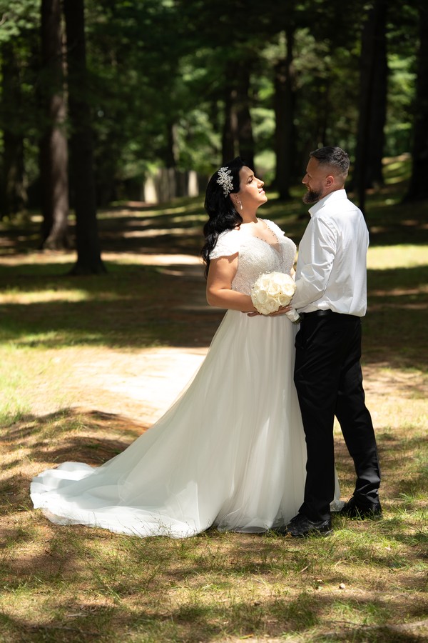 The bride’s flowing gown on a shaded garden path
