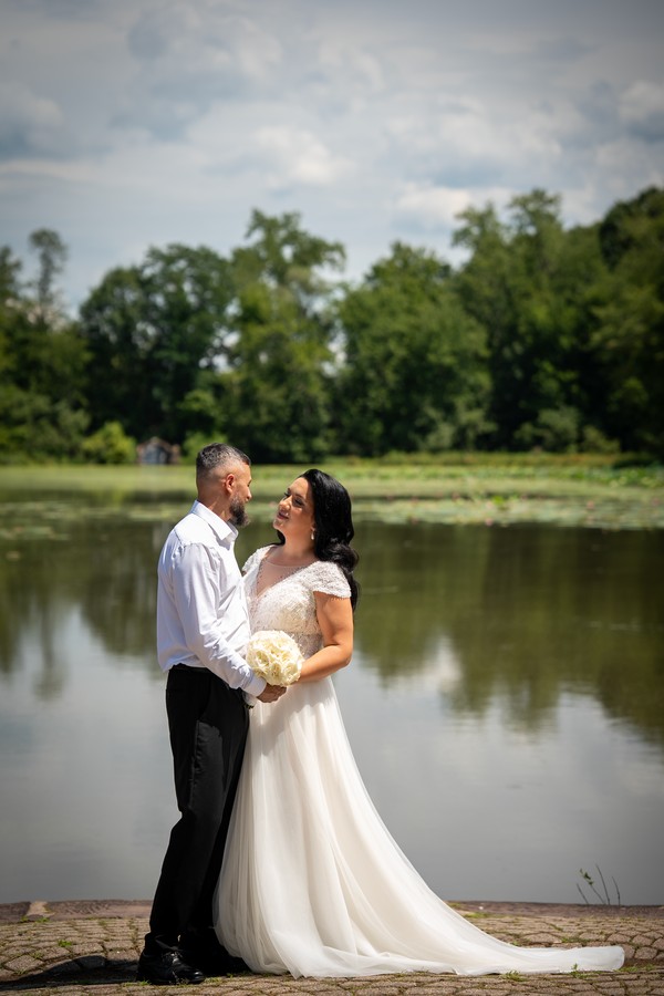 The couple beside the water beneath a summer sky