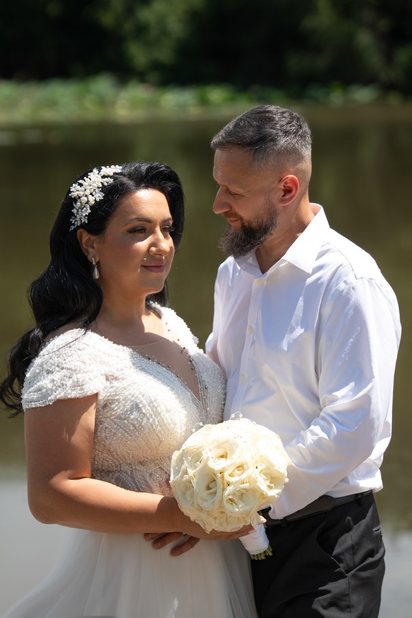 The newlyweds sharing a quiet look by the pond