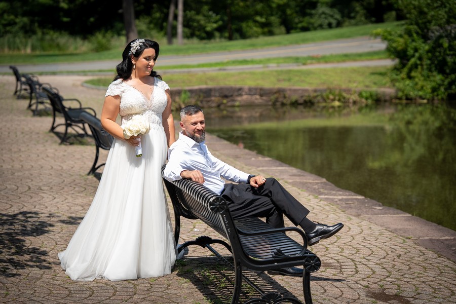The couple beside a bench on the pond-side path