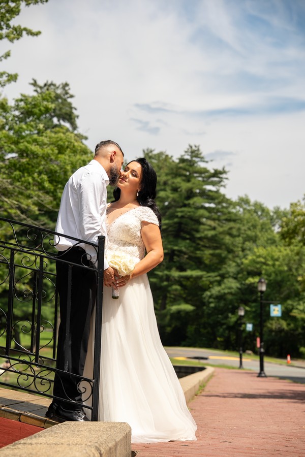 The newlyweds kissing on a small garden bridge