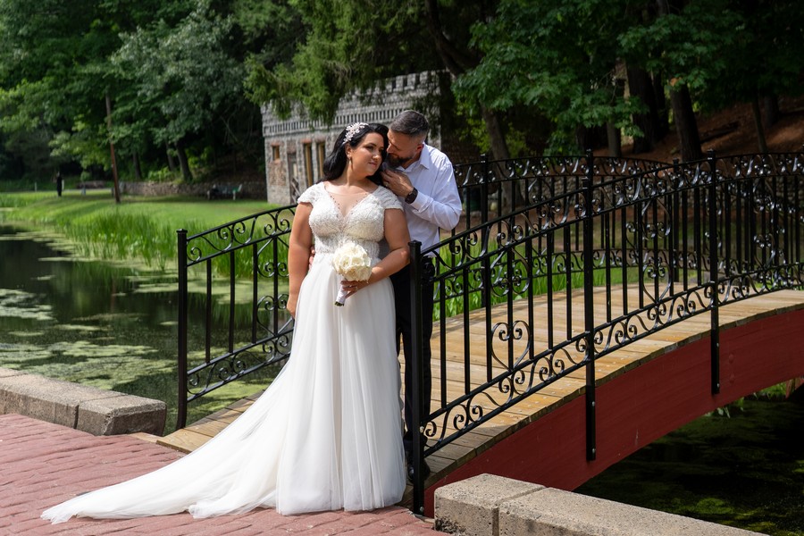 The couple embracing on the garden bridge