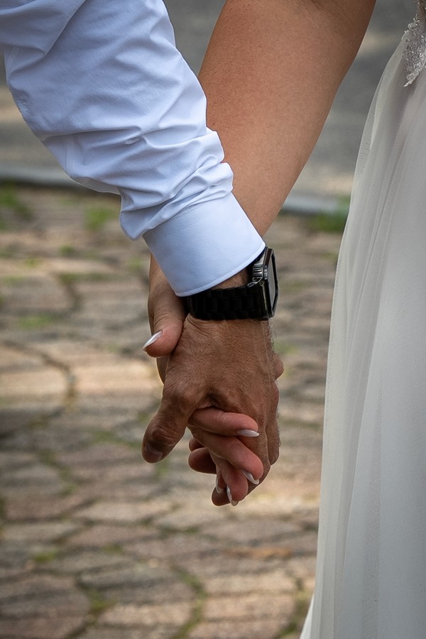 A close detail of the couple’s hands intertwined