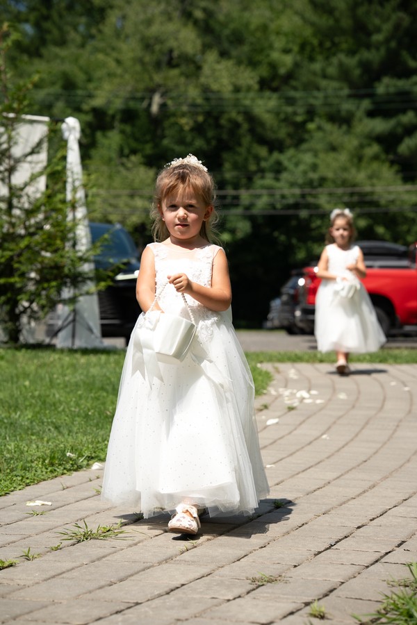 Flower girls walking toward the outdoor ceremony