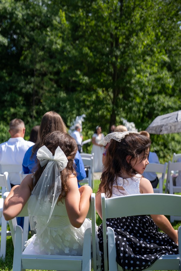 Guests seated among the trees for the wedding ceremony