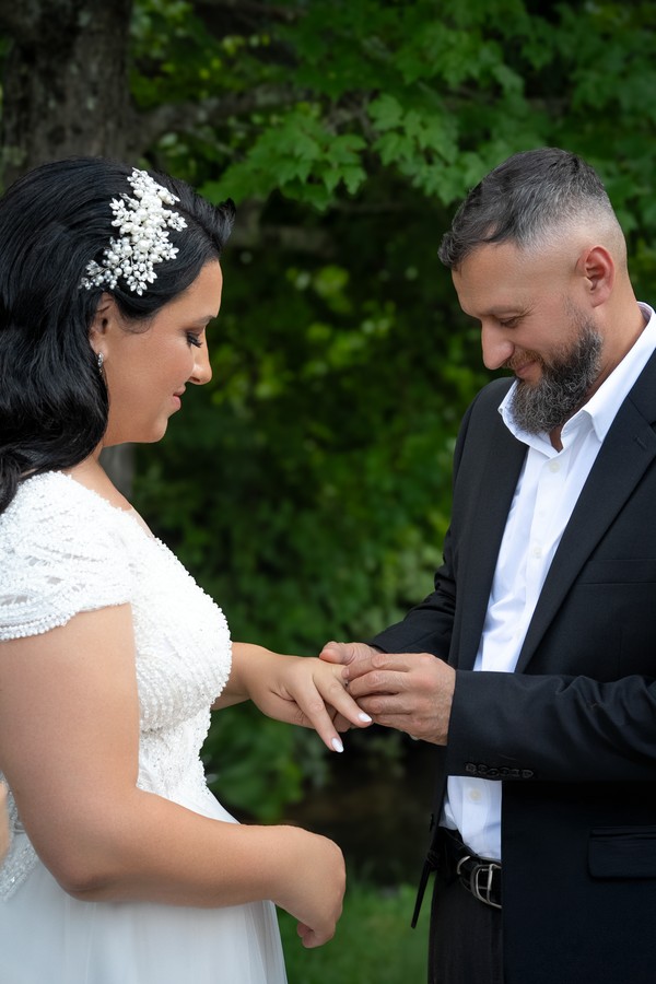 The bride placing a wedding ring on the groom’s hand