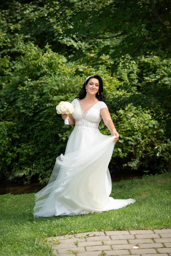 The bride smiling as she lifts her flowing skirt